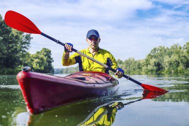 Bir adam bir kayık Nehri üzerinde güneşli bir günde sallar.