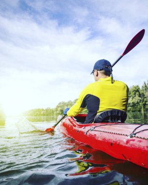 Bir adam bir kayık Nehri üzerinde güneşli bir günde sallar.