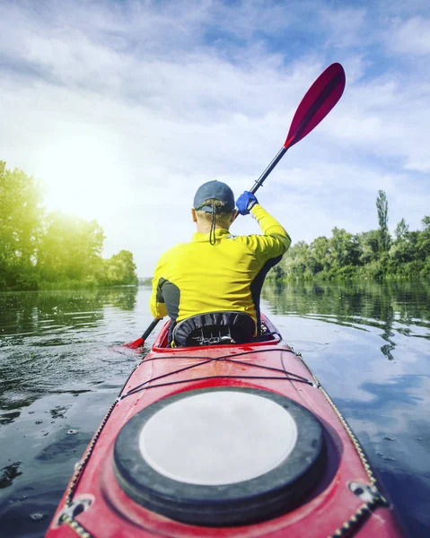 Un homme radeaux sur un kayak sur la rivière par une journée ensoleillée . — Photo