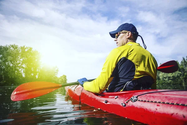 En man flottar på en kajak på floden i en solig dag. — Stockfoto