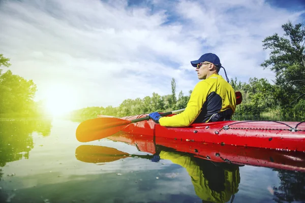 Bir adam bir kayık Nehri üzerinde güneşli bir günde sallar.