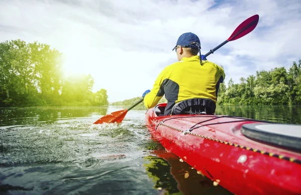 Un homme radeaux sur un kayak sur la rivière par une journée ensoleillée . — Photo