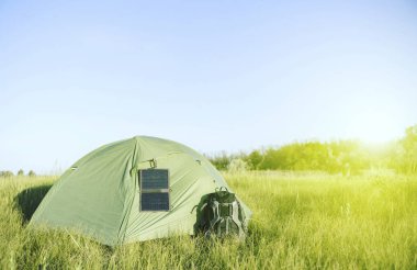 Ormanda güneş paneli asılı bir açıklıkta çadır standları 