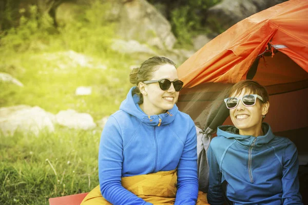 Flickorna sitter nära ett tält på en campingplats på floden förbud — Stockfoto