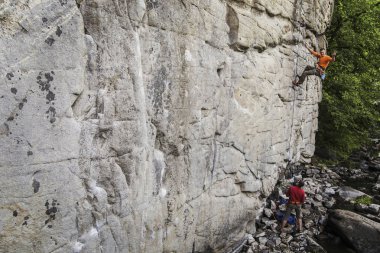 Genç bir adam bir kanyonda tırmanıyor.
