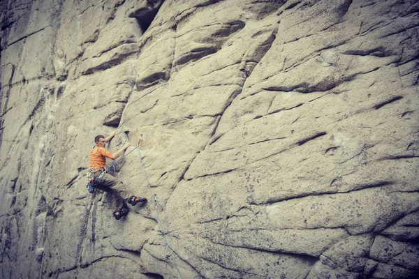 Een jonge man klimt in een canyon. — Stockfoto