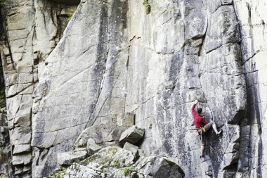 Genç bir adam bir kanyonda tırmanıyor.