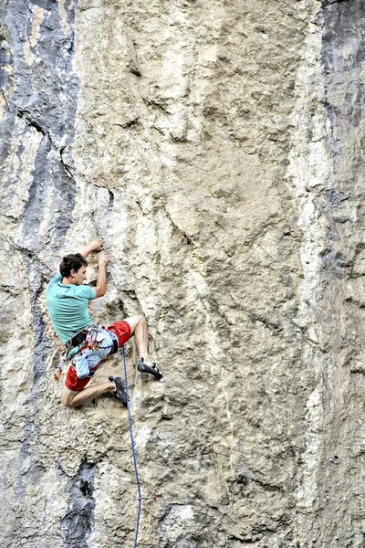 Jovem escalando em uma parede de pedra calcária com amplo vale no b — Fotografia de Stock