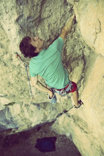 Alpinista subindo um penhasco desafiador. Escalada desportiva extrema — Fotografia de Stock