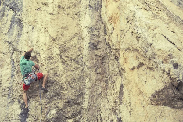 Alpinista subindo um penhasco desafiador. Escalada desportiva extrema — Fotografia de Stock