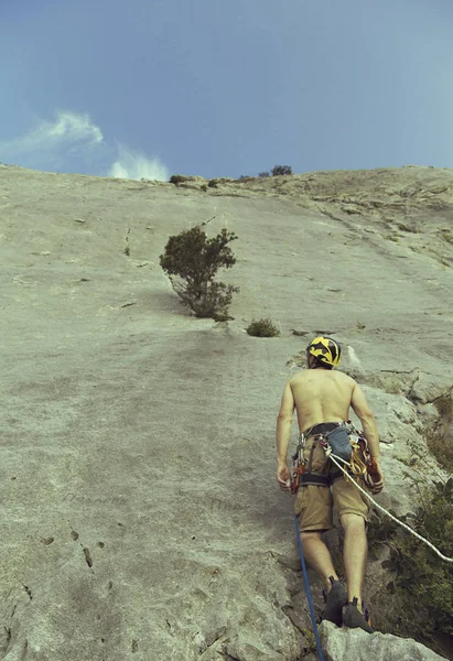 Alpinista subindo um penhasco desafiador. Escalada desportiva extrema — Fotografia de Stock