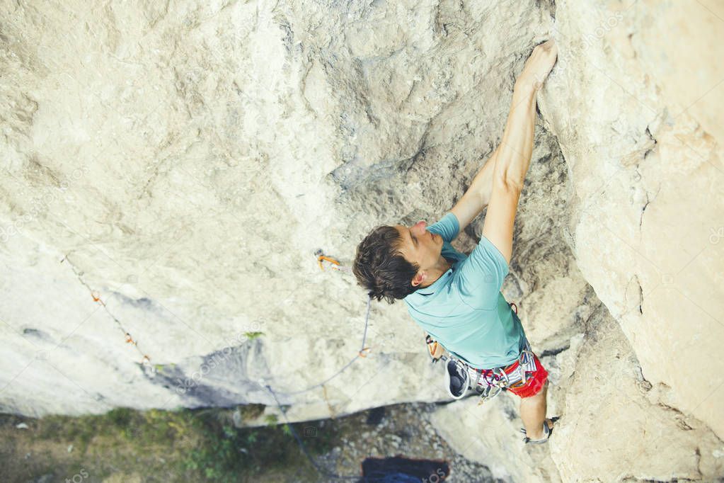 Rock climber ascending a challenging cliff. Extreme sport climbi