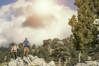 Uzun yürüyüşe çıkan kimse sırt çantaları ile dağ tepe zirvesine ulaşır. Başarı