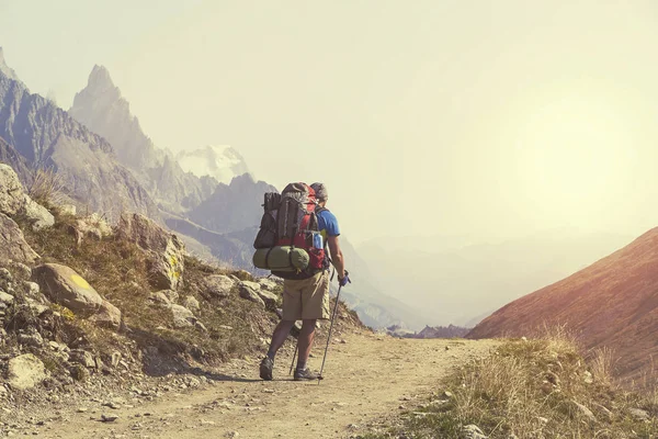 Senderista con mochilas alcanza la cima del pico de la montaña. Éxitos — Foto de Stock