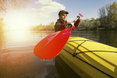 Nehirde bir kayık kürek çekmeye adam.