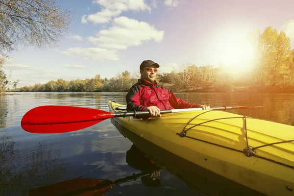 Nehirde bir kayık kürek çekmeye adam.