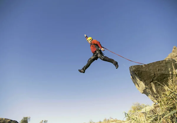 Jump off a cliff into a canyon with a rope. — Stock Photo, Image