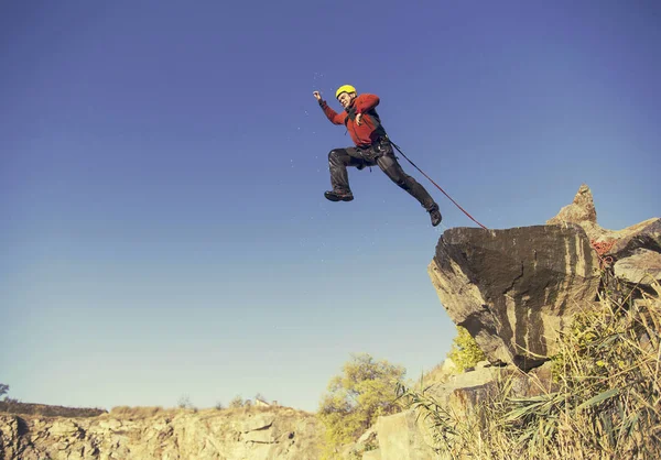 Springen van een rots in een canyon met een touw. — Stockfoto