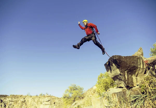 Jump off a cliff into a canyon with a rope. — Stock Photo, Image