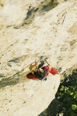 Dağcı dağın tepesine tırmanmak için.