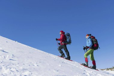 İki adam kış aylarında dağlara tırmanmak..