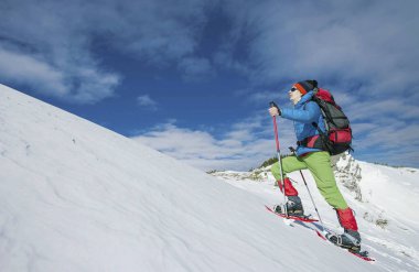 Bir adam dağlarda kışın tırmanıyor..