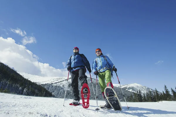 Winterwandern in den Bergen. zwei Männer schaffen den Aufstieg zum — Stockfoto