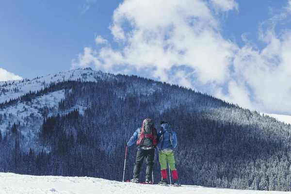 Senderismo de invierno en las montañas. Dos hombres hacen un ascenso a la — Foto de Stock