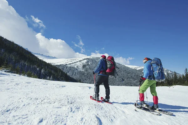 Winterwandern in den Bergen. zwei Männer schaffen den Aufstieg zum — Stockfoto