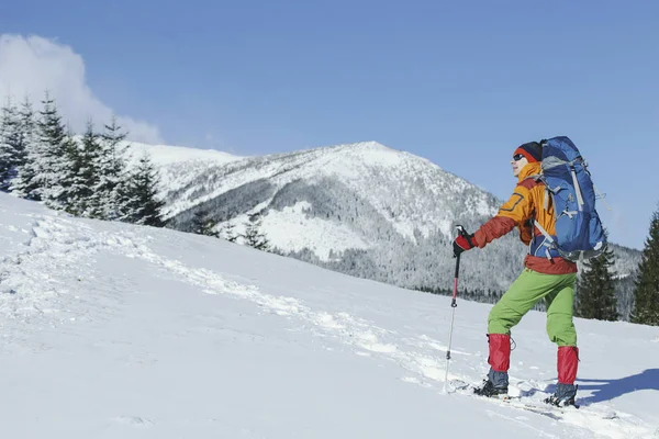 Χειμερινή πεζοπορία στα βουνά. Ένας άνθρωπος ανεβαίνει στην κορυφή. — Φωτογραφία Αρχείου