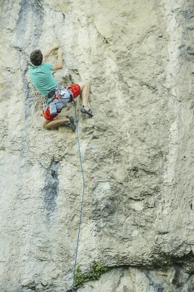 Le grimpeur grimpe le rocher. — Photo