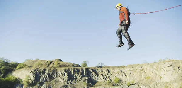 Un hombre salta al abismo contra el cielo . —  Fotos de Stock