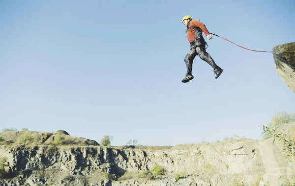 Ein Mann springt gegen den Himmel in den Abgrund. — Stockfoto