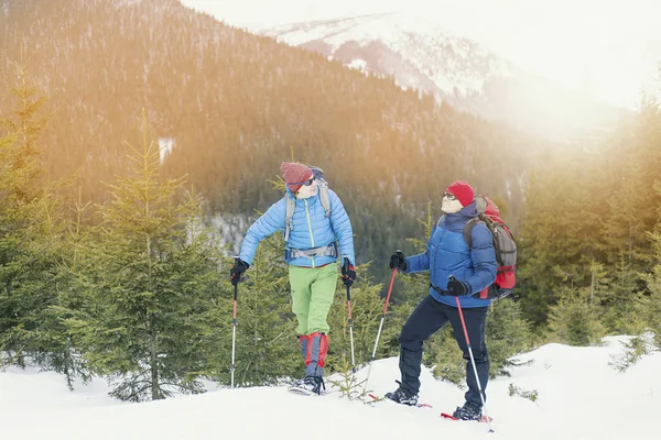 Senderismo de invierno en las montañas. Dos hombres hacen un ascenso a la —  Fotos de Stock