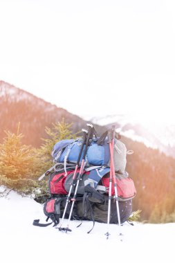 Dağlarda kış yürüyüşü. Sırt çantası dağları gören bir yamaçta duruyor..