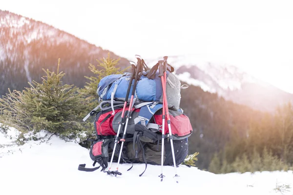Dağlarda kış yürüyüşü. Sırt çantası dağları gören bir yamaçta duruyor.. — Stok fotoğraf