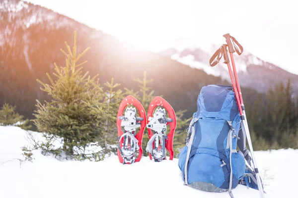 Téli túrázás a hegyekben. A hátizsák egy lejtőn áll, kilátással a hegyekre.. — Stock Fotó