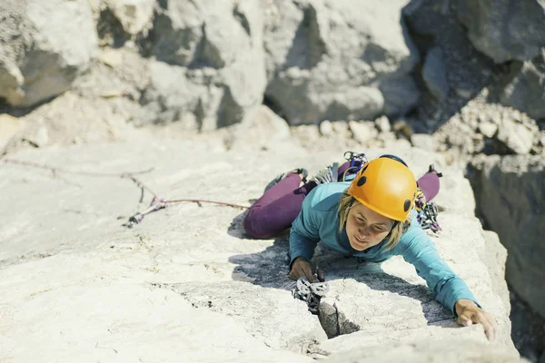 A woman climber climbs to the top of a cliff. — Stock Photo, Image