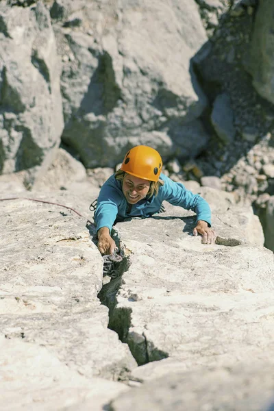 A woman climber climbs to the top of a cliff. — Stock Photo, Image