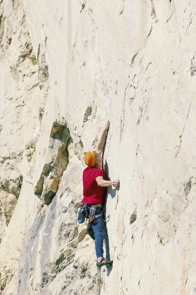 Climber erkeği bir uçurumun tepesine tırmanıyor. — Stok fotoğraf