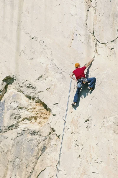 Un grimpeur monte au sommet d'une falaise . — Photo