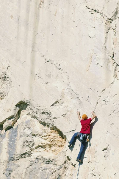 Ein Bergsteiger klettert auf die Spitze einer Klippe. — Stockfoto