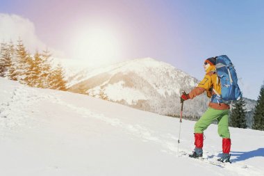 Bir kış gezi dağlara. Adam üst kadar tırmanıyor.