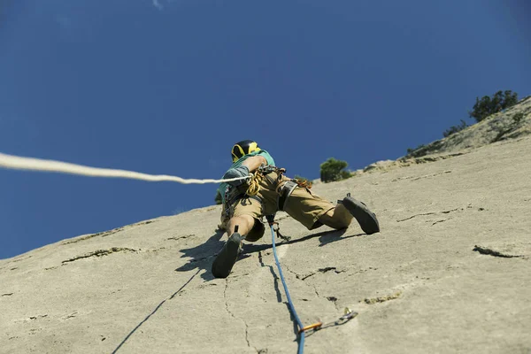 Альпинист забирается на вершину утёса . — стоковое фото