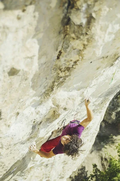 A climber climbs an ascent to a cliff. — Stock Photo, Image