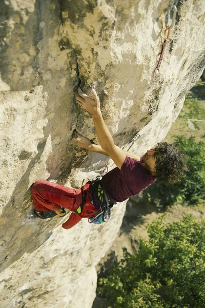 A climber climbs an ascent to a cliff. — Stock Photo, Image