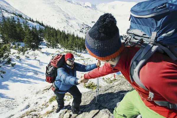 Helpen bij het overwinnen van het bergachtige terrein in de wintercampagne. — Stockfoto