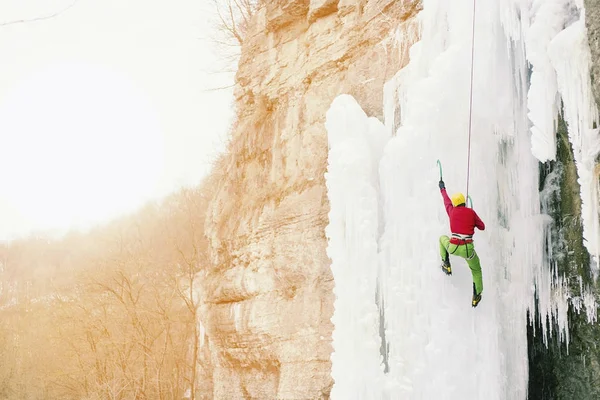 Ledové lezení na severním Kavkaze, muž stoupající zmrazené vodopád. — Stock fotografie
