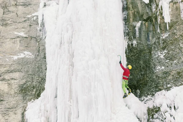 Eisklettern im Nordkaukasus, Mann besteigt gefrorenen Wasserfall. — Stockfoto