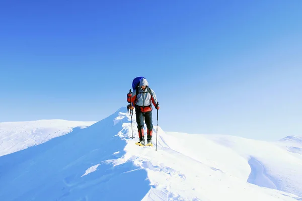 Caminata de invierno en las montañas con una mochila y tienda de campaña . —  Fotos de Stock